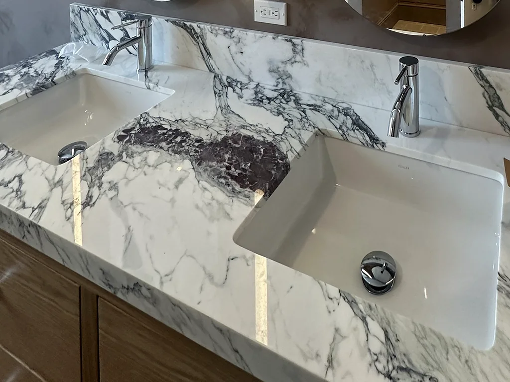 Purple-veined marble vanity top with undermount sinks and chrome faucets